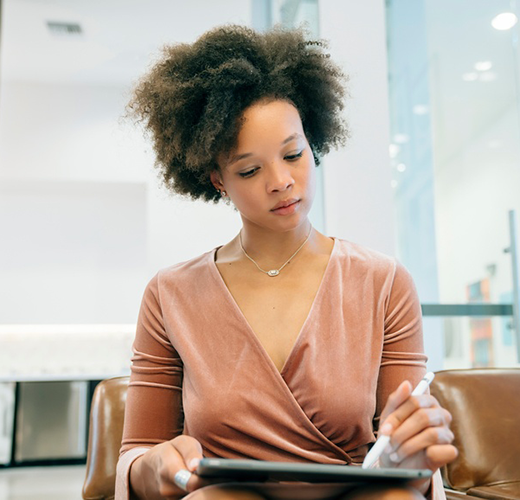 Women wearing a wrap blouse working on a tablet