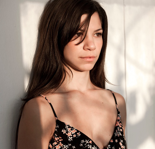women leaning on a wall with shadows